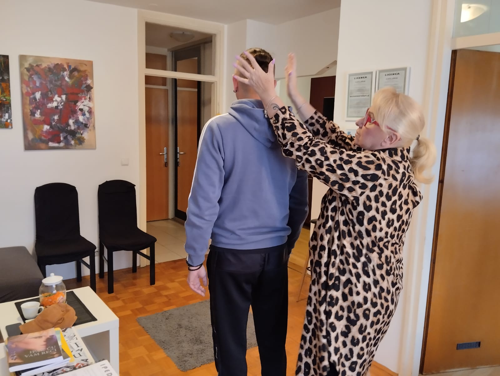 Vlasta Jašćur tijekom tretmana, s licencama za bioenergoterapiju i kristaloterapiju istaknutim na zidu u pozadini